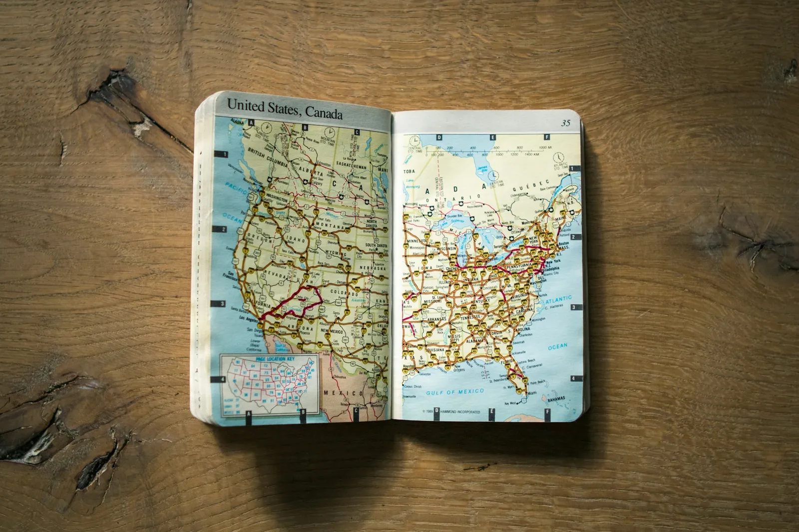 Printed paper map of the United States laid flat on a brown wooden surface