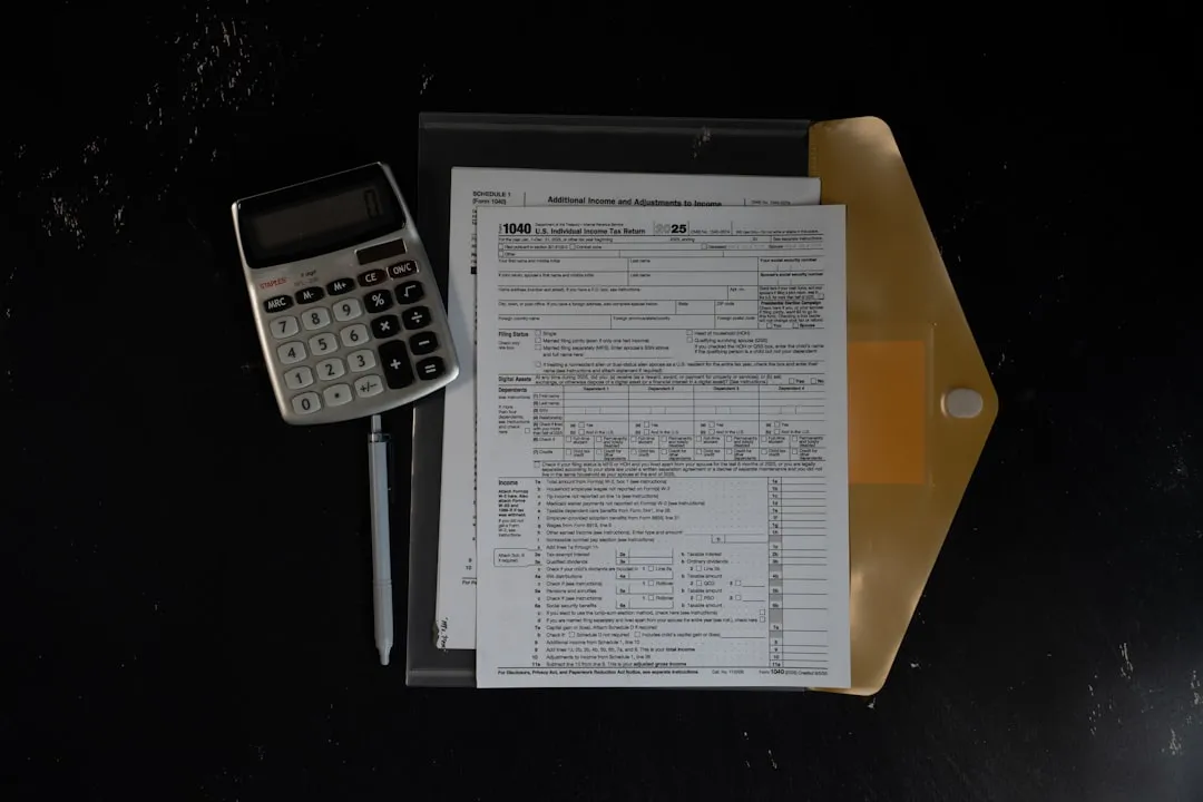 Calculator and papers in a folder on a dark surface