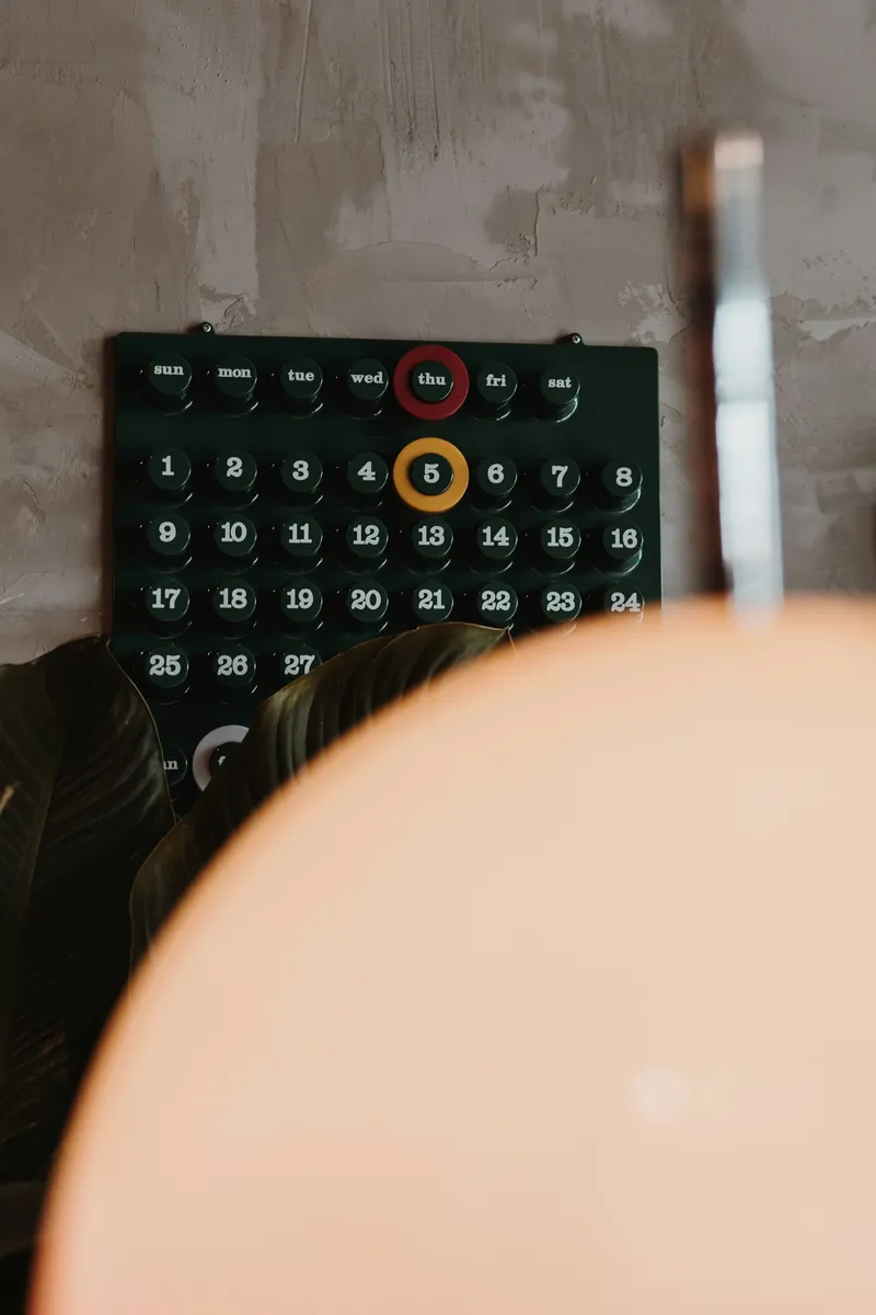 Close-up of a dark monthly calendar grid with numbered days and several dates highlighted in a contrasting color