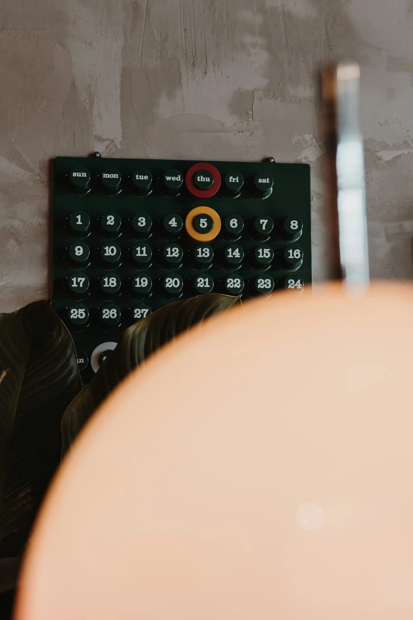 Close-up of a dark monthly calendar grid with numbered days and several dates highlighted in a contrasting color