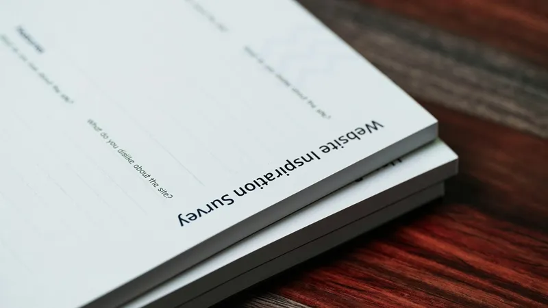 Stack of printed paper documents resting on a warm wooden tabletop